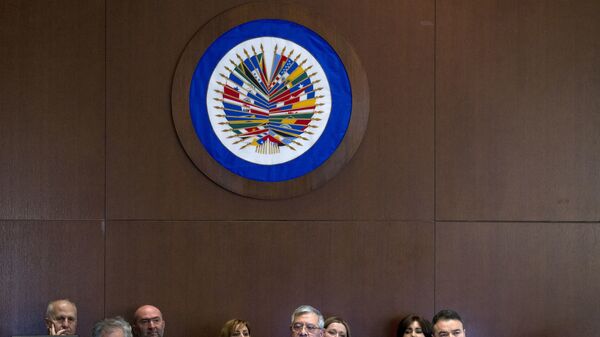 Organization of American States (OAS) Chair of the Permanent Council and Permanent Representative of Honduras Leonidas Rosa Bautista, center, accompanied by Organization of American States (OAS) Secretary General Luis Almagro Lemes, left, speaks before the Permanent Council of the Organization of American States (OAS) in Washington - Sputnik Mundo