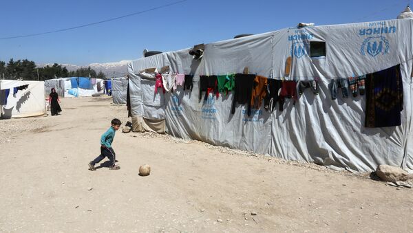 A Syrian refugee boy plays outside tents at a makeshift settlement in Bar Elias town, in the Bekaa valley - Sputnik Mundo