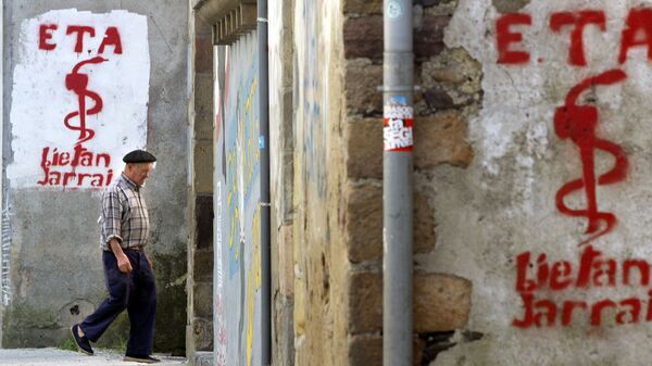 An old man walks past graffiti depicting the logo of Basque separatist group ETA in Goizueta - Sputnik Mundo
