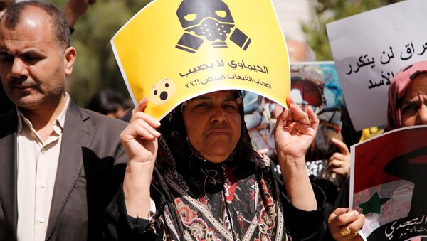 Una manifestante contraria al ataque aéreo de EEUU en Siria porta una pancarta en la que puede leerse: ¿Los productos químicos no afectan a los Cascos Blancos? - Sputnik Mundo