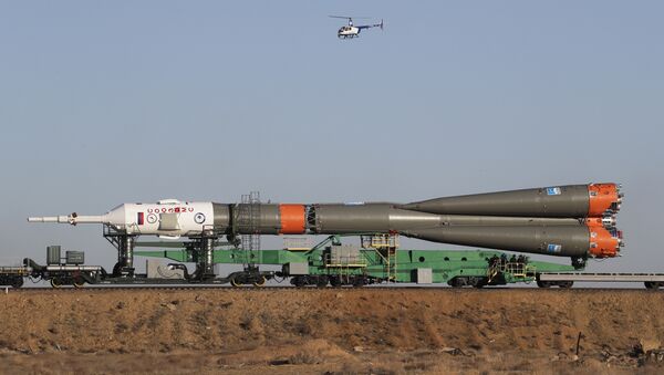 A helicopter flies over Russia's Soyuz-FG booster rocket with the Soyuz MS-04 space ship - Sputnik Mundo