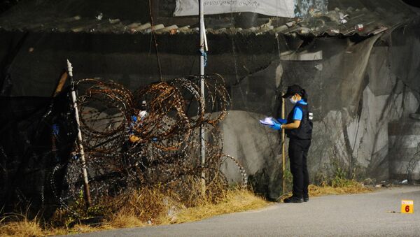 El miembro de la unidad forense inspecta el lugar del atentado fuera de la comisaría de policía en Tailandia - Sputnik Mundo