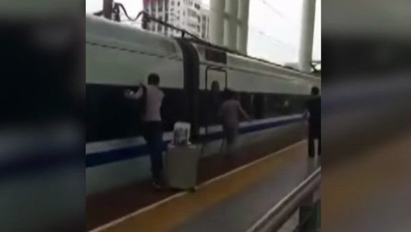 Un pasajero intenta desatascar sus dedos de un tren en marcha - Sputnik Mundo
