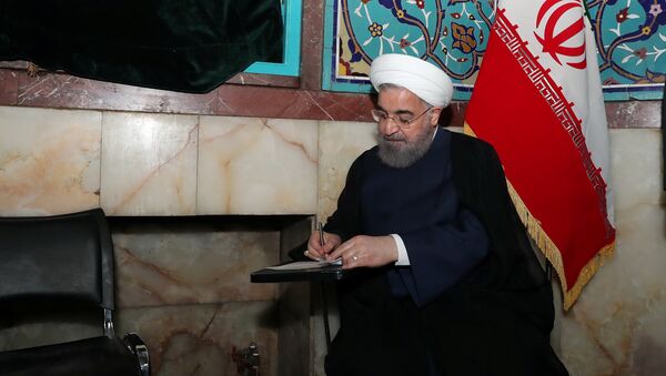 Iran's President Hassan Rouhani fills in his ballot - Sputnik Mundo