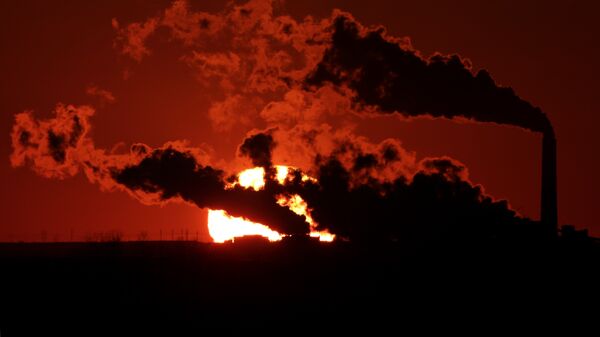 In this March 8, 2014, file photo steam from the Jeffrey Energy Center coal-fired power plant is silhouetted against the setting sun near St. Marys, Kan. - Sputnik Mundo