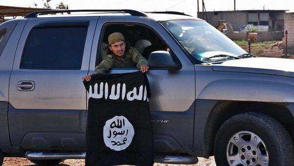 Un combatiente del Ejercito Libre Sirio con la bandera de Daesh - Sputnik Mundo