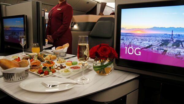 Azafata de Qatar Airways presenta asientos de la primera clase de un Boeing 777 - Sputnik Mundo