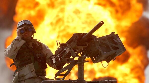 A US soldier looks through a pair of binoculars as a fire in the Rumeila oil field burns in the background in southern of Iraq, Sunday, March. 30, 2003 - Sputnik Mundo