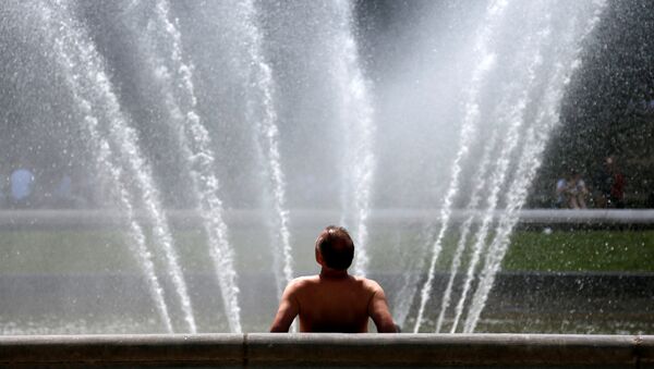 Un hombre en una fuente salvándose del calor enorme, Bruselas, Bélgica - Sputnik Mundo