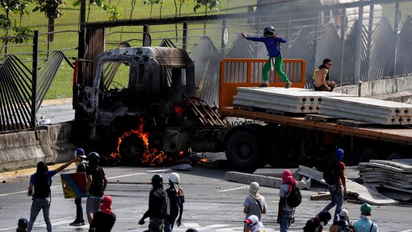 Manifestantes de oposición tumban rejas de base aérea militar venezolana en Caracas - Sputnik Mundo