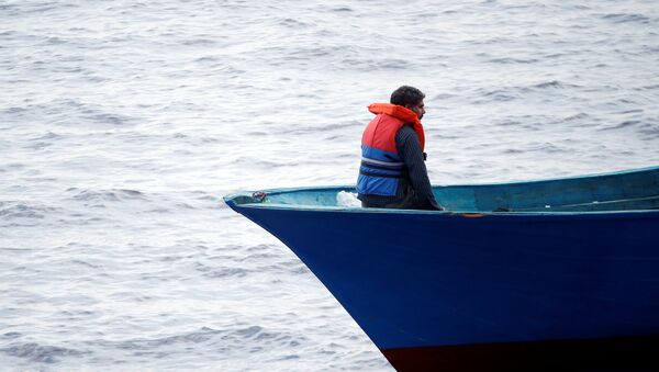Un migrante en un barco en el Mediterráneo (archivo) - Sputnik Mundo