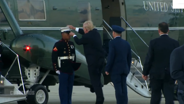 Donald Trump, presidente de Estados Unidos, intentó ayudar a un soldado que había perdido su gorra debido a unas fuertes ráfagas de viento - Sputnik Mundo