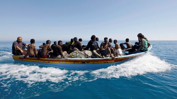 Los migrantes en un barco en el Mediterráneo - Sputnik Mundo