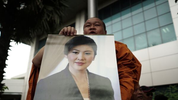 Un monje con la foto de la ex primera ministra de Tailandia, Yingluck Shinawatra - Sputnik Mundo
