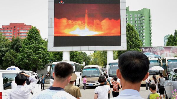 Personas observando el nuevo lanzamiento del misil en un estación de Pyongyang - Sputnik Mundo