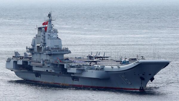 Miembros de la Armada china son vistos a bordo del portaviones Liaoning mientras navega hacia Hong Kong (imagen referencial) - Sputnik Mundo
