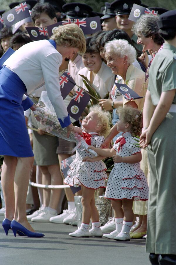 Hermanas gemelas regalan flores a la princesa Diana durante el último día de su gira asiática en Hong Kong, en 1989 - Sputnik Mundo