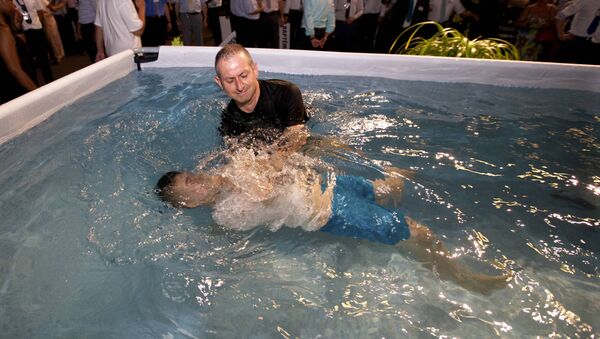Una ceremonia del baptismo de los Testigos de Jehová - Sputnik Mundo