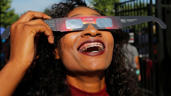 Una muchacha prueba gafas con filtro solar antes del eclipse del Sol del 21 de agosto de 2017 - Sputnik Mundo