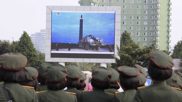 Los nortecoreanos, viendo el lanzamiento del misil balístico, en Pyongyang - Sputnik Mundo