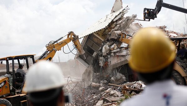Excavadores derruyen una casa devastada por el terremoto del 19 de septiembre en Jojutla de Juárez, México - Sputnik Mundo