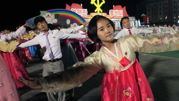 North Korean men and women participate in a mass dance event marking the 20th anniversary of the election of former leader Kim Jong Il as general secretary of the Workers' Party, which is the founding and ruling party of North Korea, at Kim Il Sung Square in Pyongyang, Sunday, Oct. 8, 2017 - Sputnik Mundo