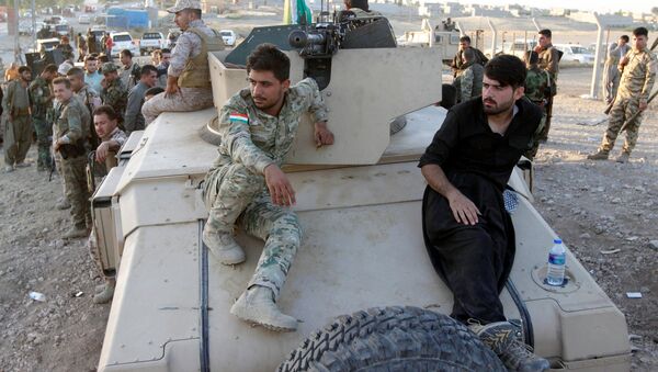 Kurdish Peshmerga fighters sit on a military vehicle north of Kirkuk, Iraq - Sputnik Mundo