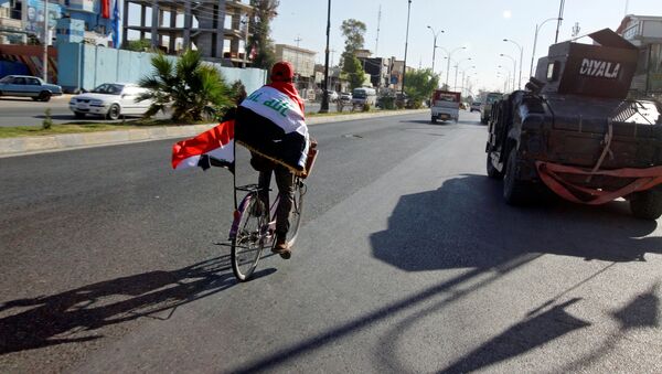 Un hombre con las banderas de Irak en la ciudad de Kirkuk - Sputnik Mundo