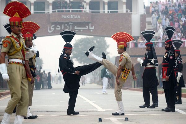 Guardafronteras paquistaníes e indios, durante la ceremonia diaria de descenso de banderas en el puesto fronterizo de Wagah. - Sputnik Mundo