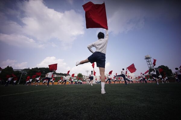 Hijos de emigrantes de Corea realizan ejercicios con banderas durante las actividades en Tokio. - Sputnik Mundo