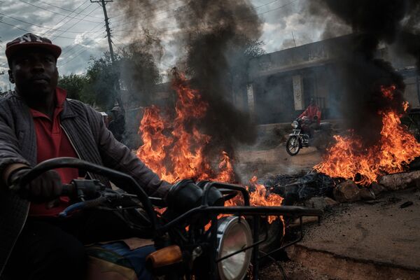Conductores de mototaxi esquivan las barricadas erigidas durante las protestas en Maengo (Kenia). - Sputnik Mundo
