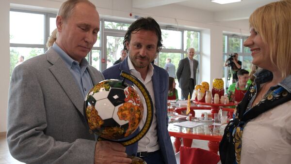 El presidente Vladímir Putin con el globo futbolero con jojlomá - Sputnik Mundo