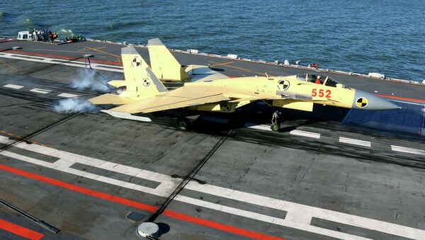In this undated photo released by China's Xinhua News Agency, a carrier-borne J-15 fighter jet lands on China's first aircraft carrier, the Liaoning - Sputnik Mundo