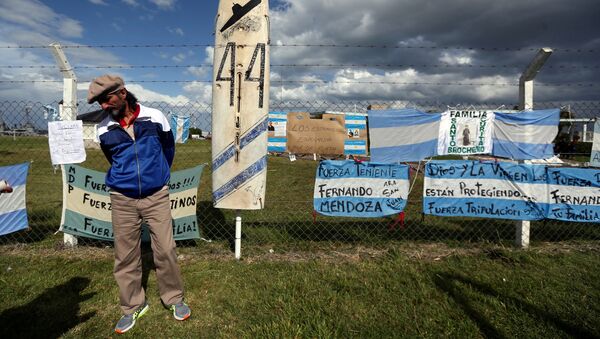 A man stands in front of signs in support of the 44 crew members of the ARA San Juan submarine - Sputnik Mundo