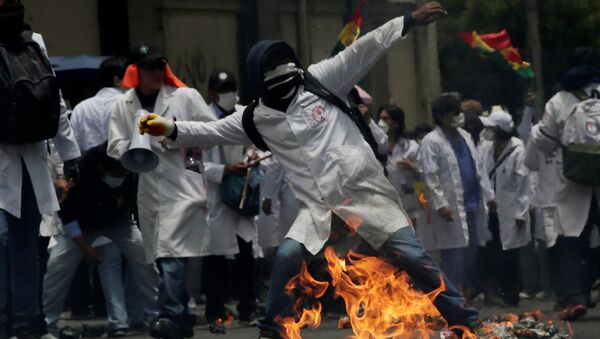 A demonstrator is seen during clashes with riot police as healthcare employees and students refuse new government policies about health system in La Paz, Bolivia - Sputnik Mundo