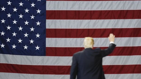Donald Trump, presidente de EEUU, con la bandera del país al fondo - Sputnik Mundo