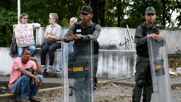 Una mujer sostiene un cartel Soy Óscar Pérez ante las fuerzas de seguridad en Caracas, Venezuela - Sputnik Mundo