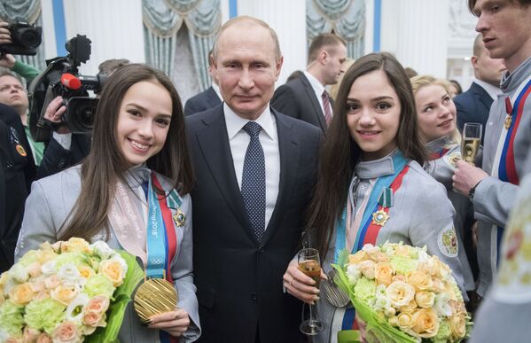 Vladímir Putin con las campeonas de patinaje artístico femenino de los JJOO de Invierno de 2018 en Pyeongchang, Alina Zaguitova y Evguenia Medvédeva, tras la ceremonia de entrega de premios estatales a los atletas en el Kremlin - Sputnik Mundo