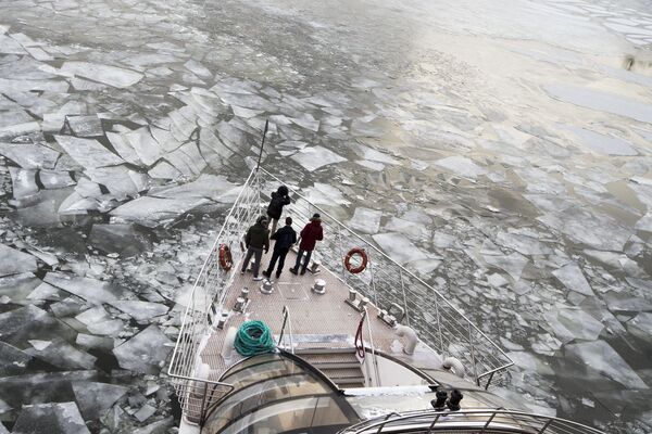 Pasajeros en la cubierta de un barco turístico navegan a lo largo del río Moscova congelado. - Sputnik Mundo