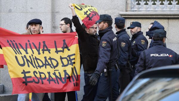 La policía española monta guardia junto a dos hombres con banderas españolas que dicen Viva la unidad de España - Sputnik Mundo