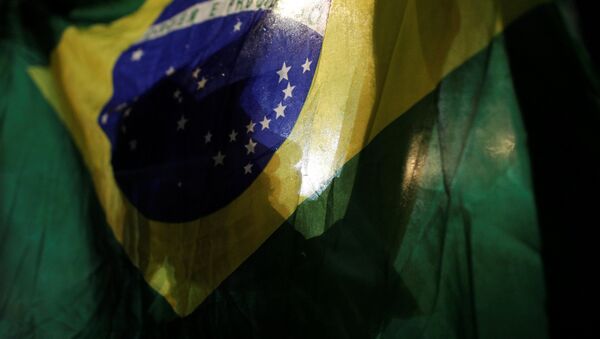 Un manifestante con la bandera de Brasil - Sputnik Mundo