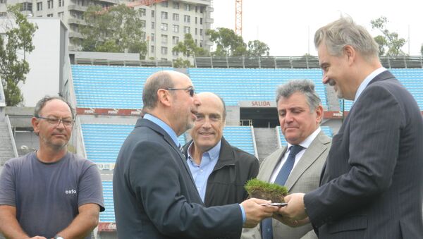 El subsecretario Nacional de Deporte de Uruguay, Alfredo Etchandy, hace entrega al embajador de Rusia en Montevideo, Nikolái Sofinski, de un pan de césped del histórico estadio Centenario - Sputnik Mundo