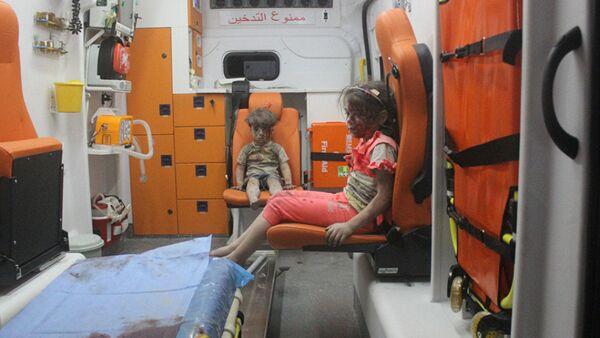 5-year-old Omran Daqneesh and his sister sit in an ambulance after being pulled out of a building hit by an airstrike in Aleppo, Syria, on Aug. 17, 2016 - Sputnik Mundo