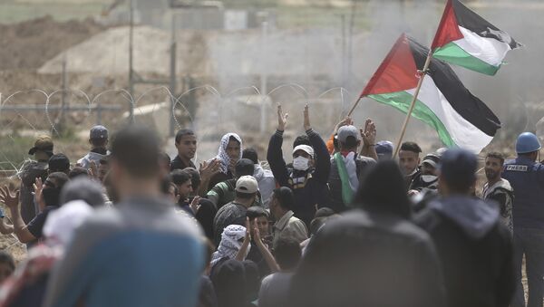 Palestinian protesters chant slogans as they gather during a protest at the Gaza Strip's border with Israel, Friday, April 13, 2018 - Sputnik Mundo
