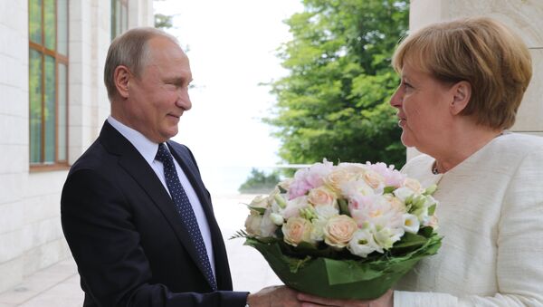 El presidente ruso Vladímir Putin regala flores a la canciller alemana, Angela Merkel - Sputnik Mundo