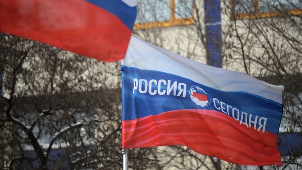 Bandera rusa con el logotipo de la Agencia de Información Internacional Rossiya Segodnya - Sputnik Mundo