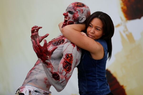 Девушка фотографируется с зомби на крупнейшей в мире игровой конвенции, Лос-Анджелес - Sputnik Mundo