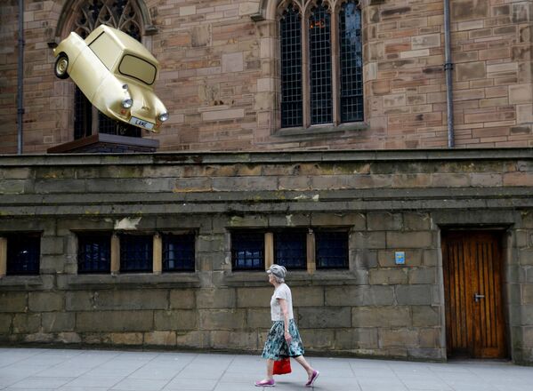 Женщина проходит мимо инсталляции Gold Lamé художника Тони Хитона в британском городе Ливерпуль - Sputnik Mundo