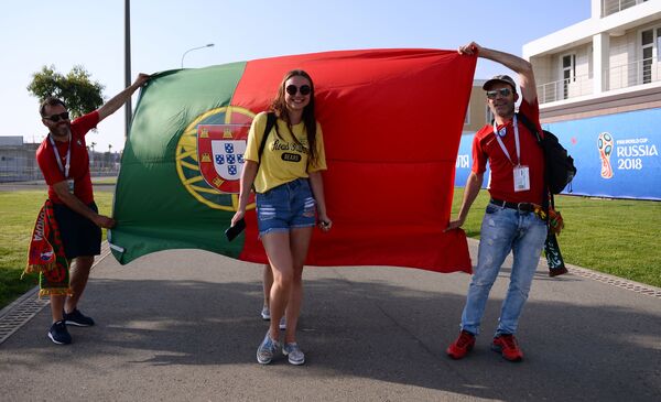Fans of Portugal's team posing in front of the country's flag ahead of a group stage World Cup match between Spain and Portugal. - Sputnik Mundo