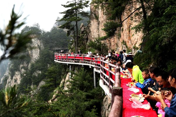 Varios turistas, en pleno banquete en el despeñadero de la montaña de Laojun (China). - Sputnik Mundo